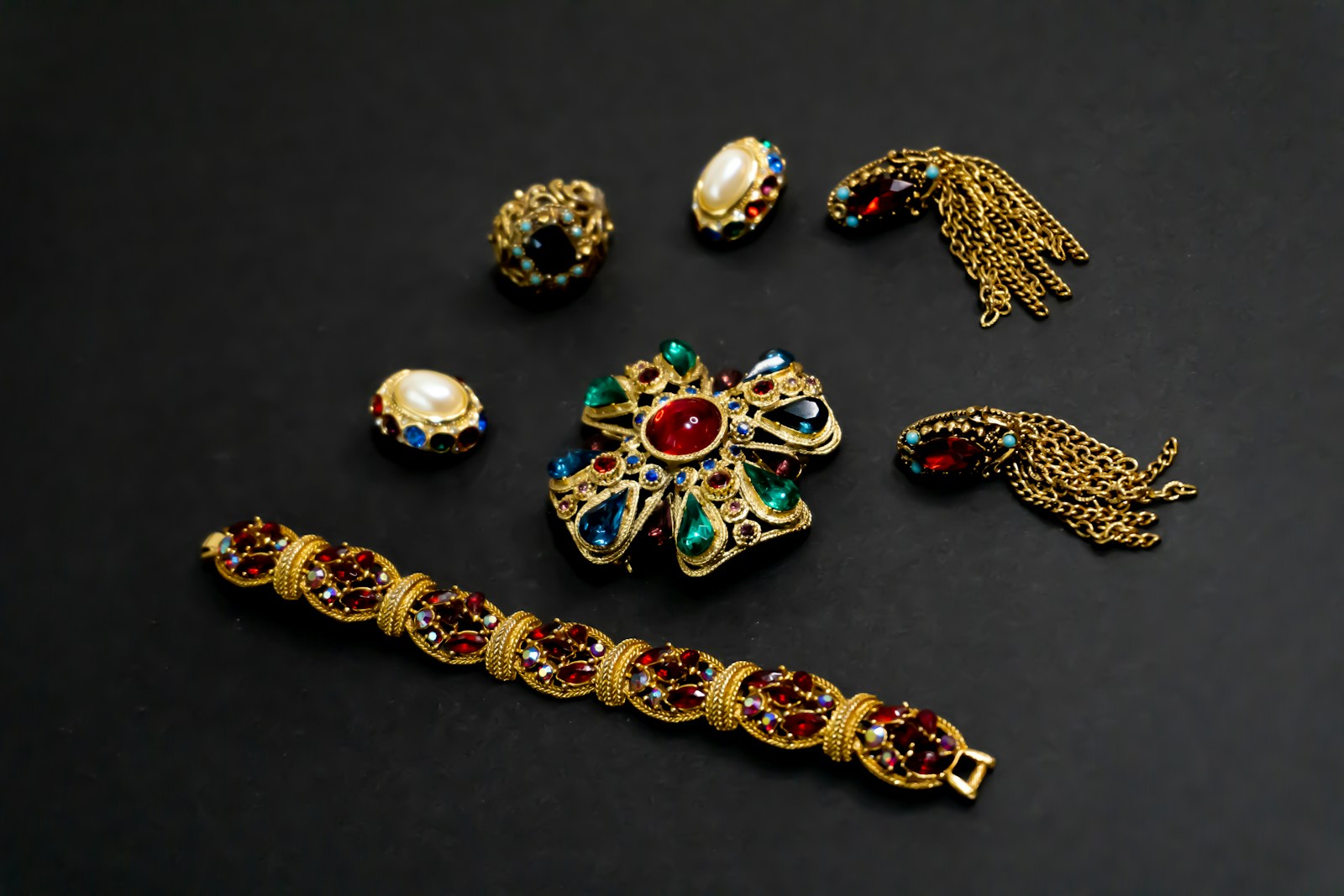 a collection of jewelry on a black surface